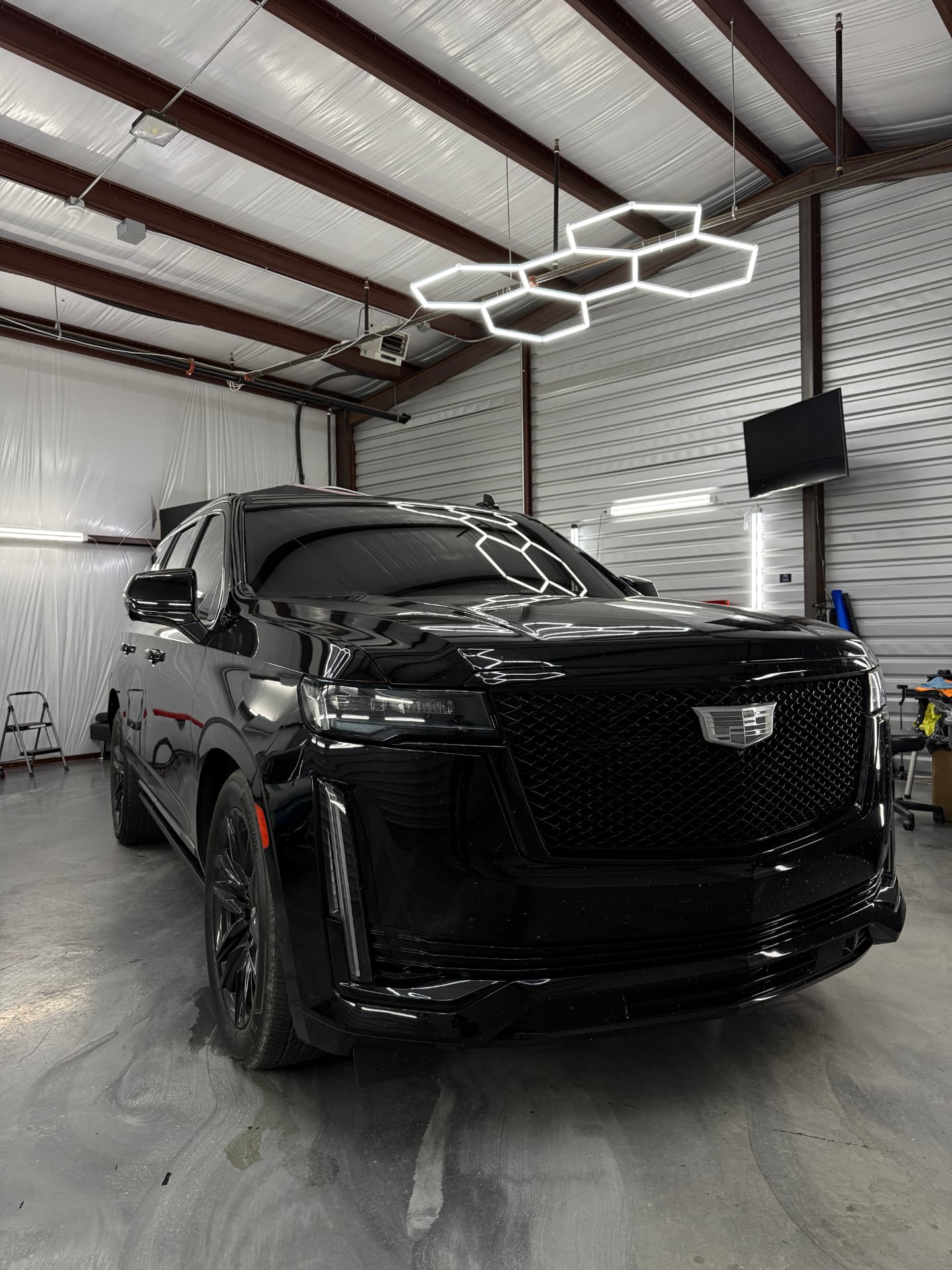 Black Cadillac Escalade with freshly installed window tint under the shop lights at JJ’s Car Care in Terrell