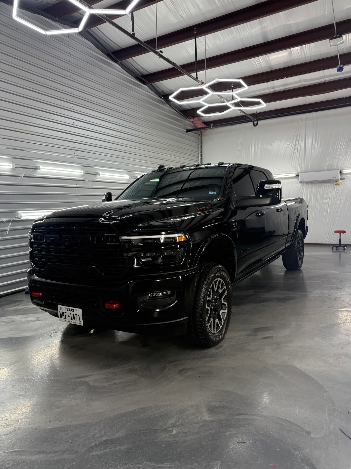 Black Ram heavy-duty pickup with dark tinted windows in the JJ’s Car Care shop in Terrell