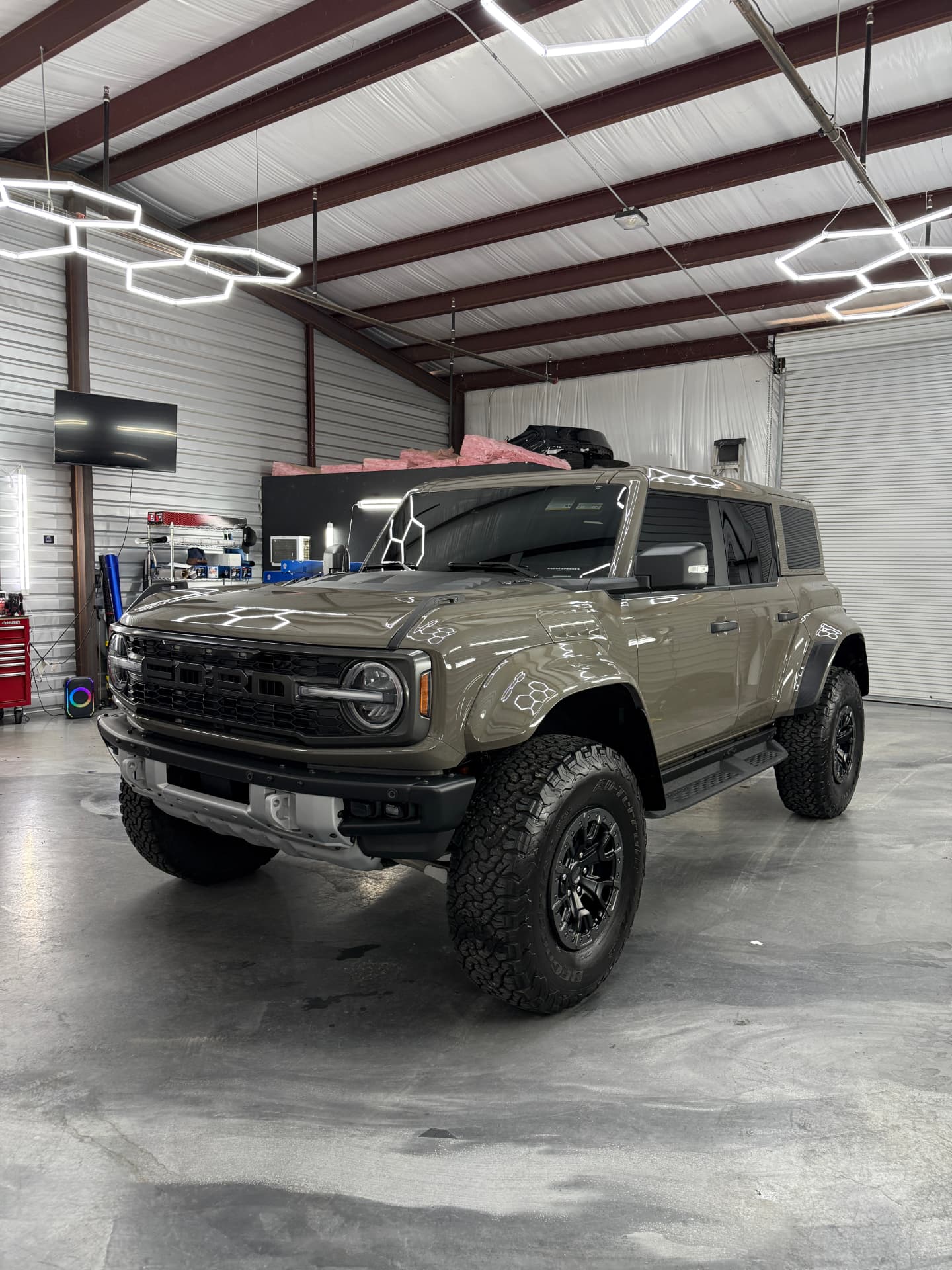 Bronco Raptor under shop lights at JJ’s Car Care in Terrell, front three-quarter view