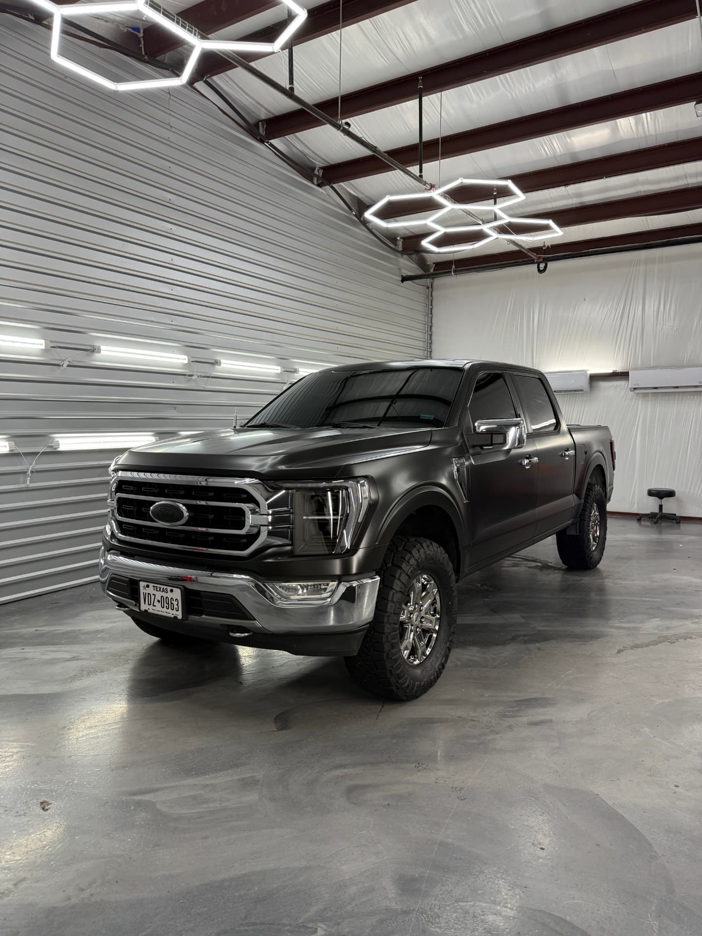 Satin black Ford F-150 with a vinyl wrap finish in the JJ’s Car Care shop in Terrell